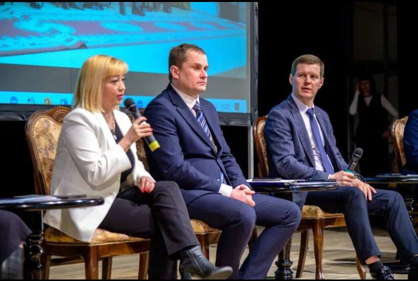 Римма выступает с микрофоном в панельной дискуссии на деловом форуме